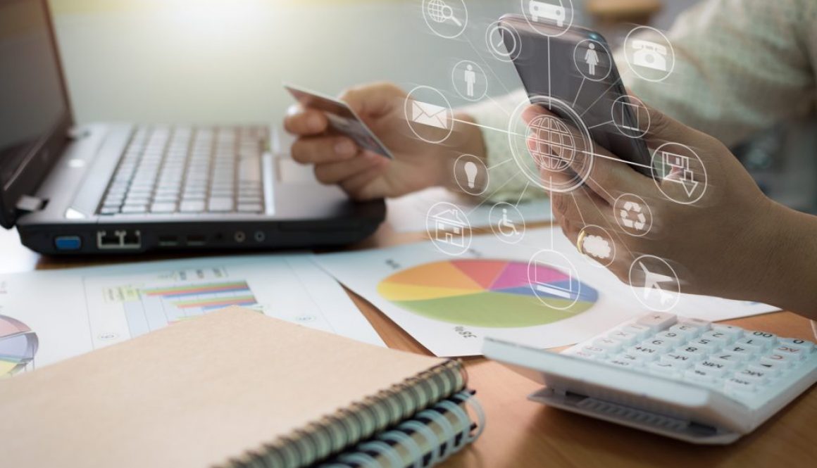 Businesswoman using mobile phone to online payment by credit card with marketing information graph and virtual graphic icon diagram in office.